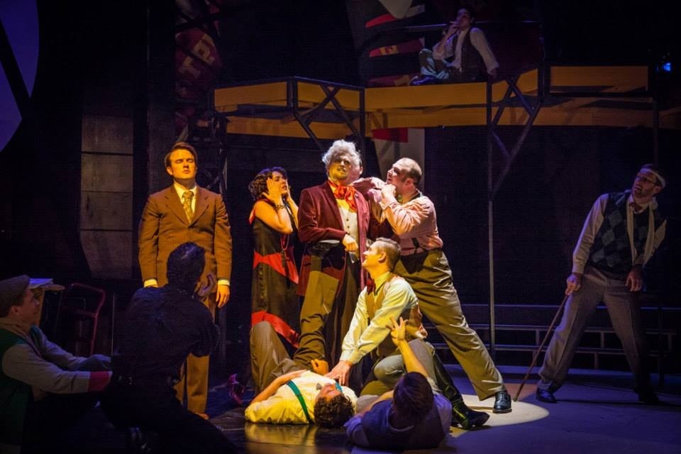 An ensemble performing on a colorful theatrical set